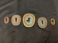Five-piece kaiguntō tsuba set arranged on dark cloth: outer spacers, two rayed seppa, central tsuba