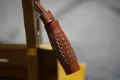 Close-up of the tooled leather slider with zigzag-cut decoration