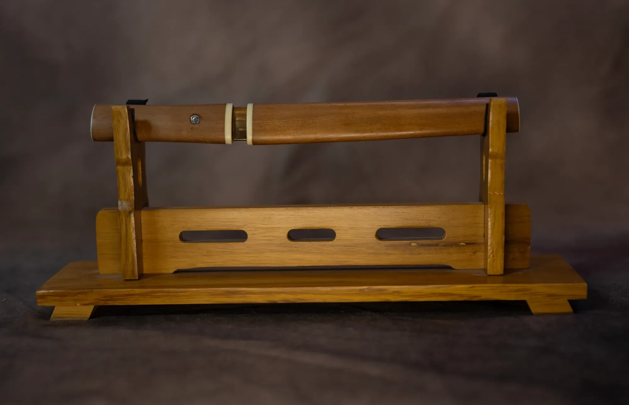The tantō in its plain wood aikuchi mounting, on a stand