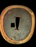 Central kaiguntō tsuba reverse showing gilt brass rim and dark field with hitsu-ana