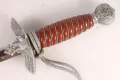 The hilt from one side, showing the downswept eagle crossguard, the orange spiral grip and the oakleaf pommel