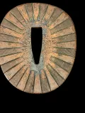 Rayed seppa close-up showing sunburst radial pattern in brass with green patina