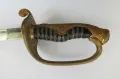 The hilt from one side, showing the pierced gilt-brass guard, scrolled pommel and black-lacquered rayskin grip