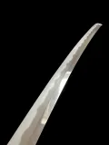 The upper blade in polish, the hamon rising towards the point