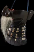 The face armour in profile with the nose lifted away, showing the red lacquer beneath and the full length of the moustache