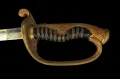 The hilt from one side, showing the pierced gilt-brass guard, scrolled pommel and black-lacquered rayskin grip