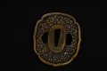 The soft-metal tsuba worked all over with cherry blossom and edged with a gilt rim