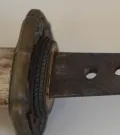 The cherry-blossom guntō tsuba, over its stack of seppa