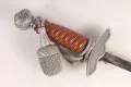 The pommel, troddel tassel and crossguard together, with the top of the blade visible