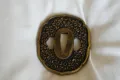 The soft-metal tsuba worked all over with cherry blossom and edged with a gilt rim