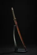 The complete koshirae displayed upright on a stand — same-wrapped tsuka, brass fuchi, and brown leather saya cover