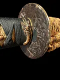 The iron dragon tsuba with its gilt fukurin, the lobster fuchi in copper and gold, and the black silk wrap over honey-coloured rayskin