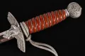 The hilt from one side, showing the downswept eagle crossguard, the orange spiral grip and the oakleaf pommel