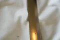 The blade catching the light along its polished length