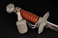The pommel, troddel tassel and crossguard together, with the top of the blade visible