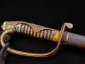 The hilt from one side: gilt knuckle bow, wire-bound grip with a cherry-blossom rosette, and the scabbard throat