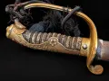 The knot and barrel of the tassel gathered against the knuckle bow