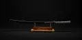 The katana mounted in its black saya on a display stand, the full koshirae with its teal-wrapped grip