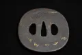 The iron tsuba off the blade, showing traces of gold inlay